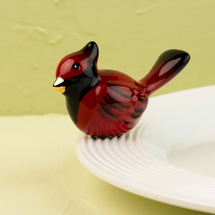 Red cardinal Nora Fleming mini on a white plate