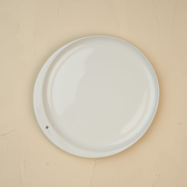Round white ceramic plate on a beige background