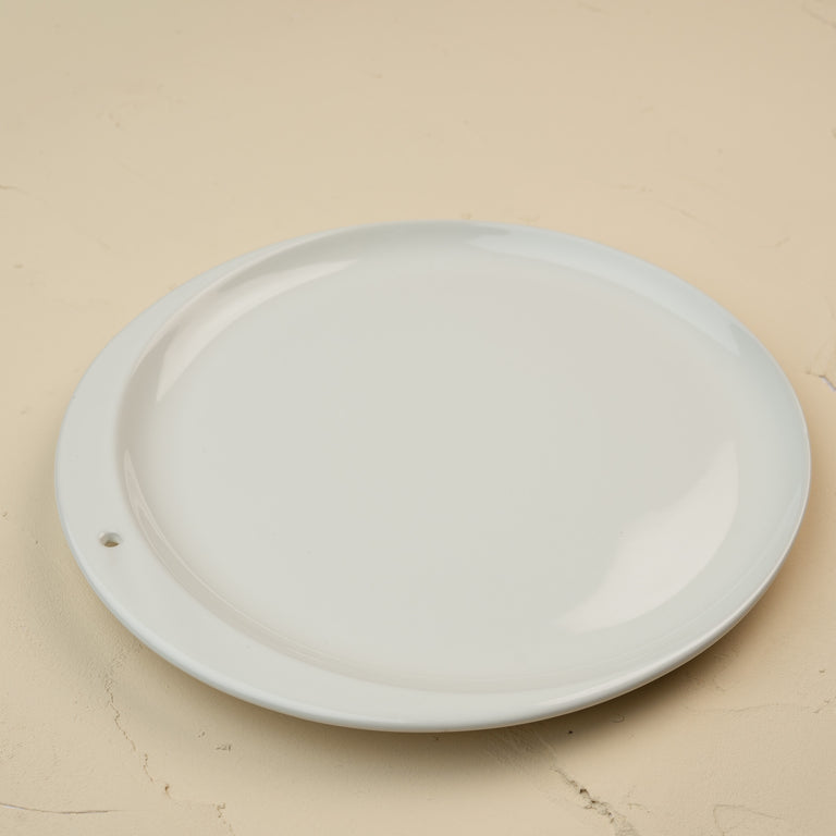 Round white ceramic plate on a beige background