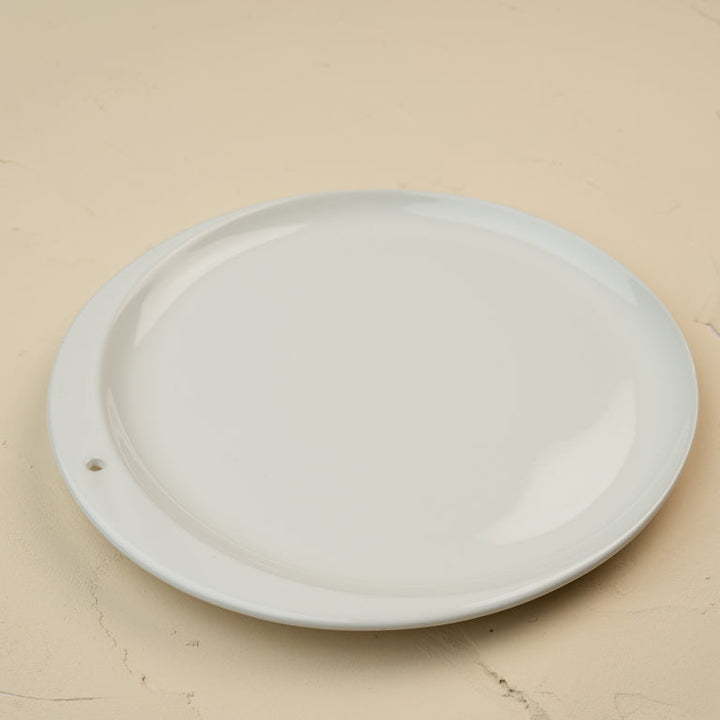 Round white ceramic plate on a beige background