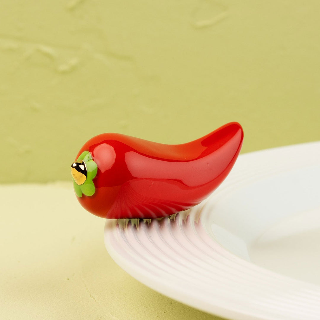 Red pepper Nora Fleming mini on a white plate
